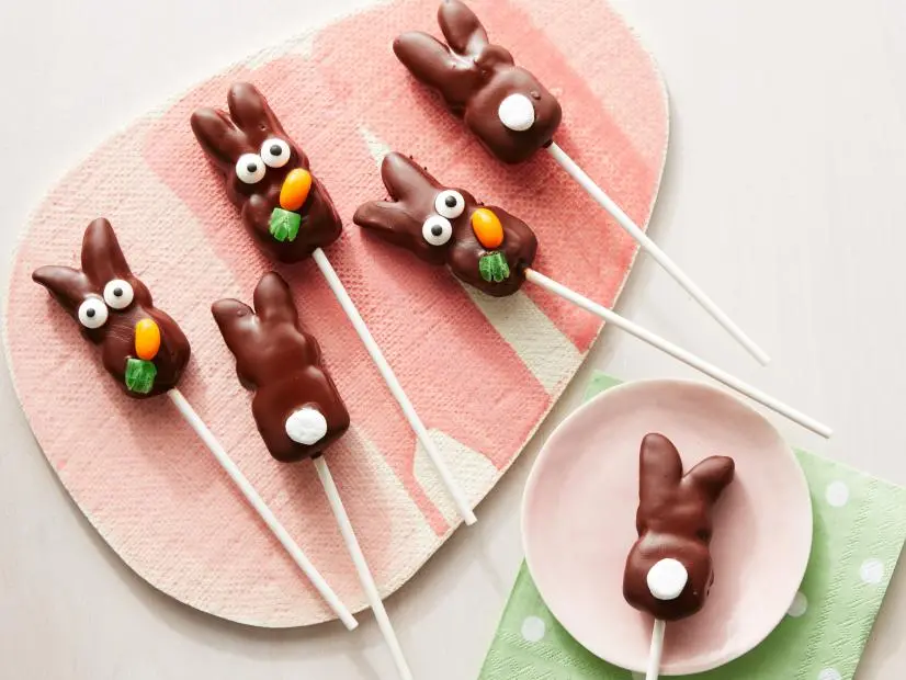 Golden chocolate-coated marshmallow bunnies on lollipop sticks topped with fluffy white marshmallow tails